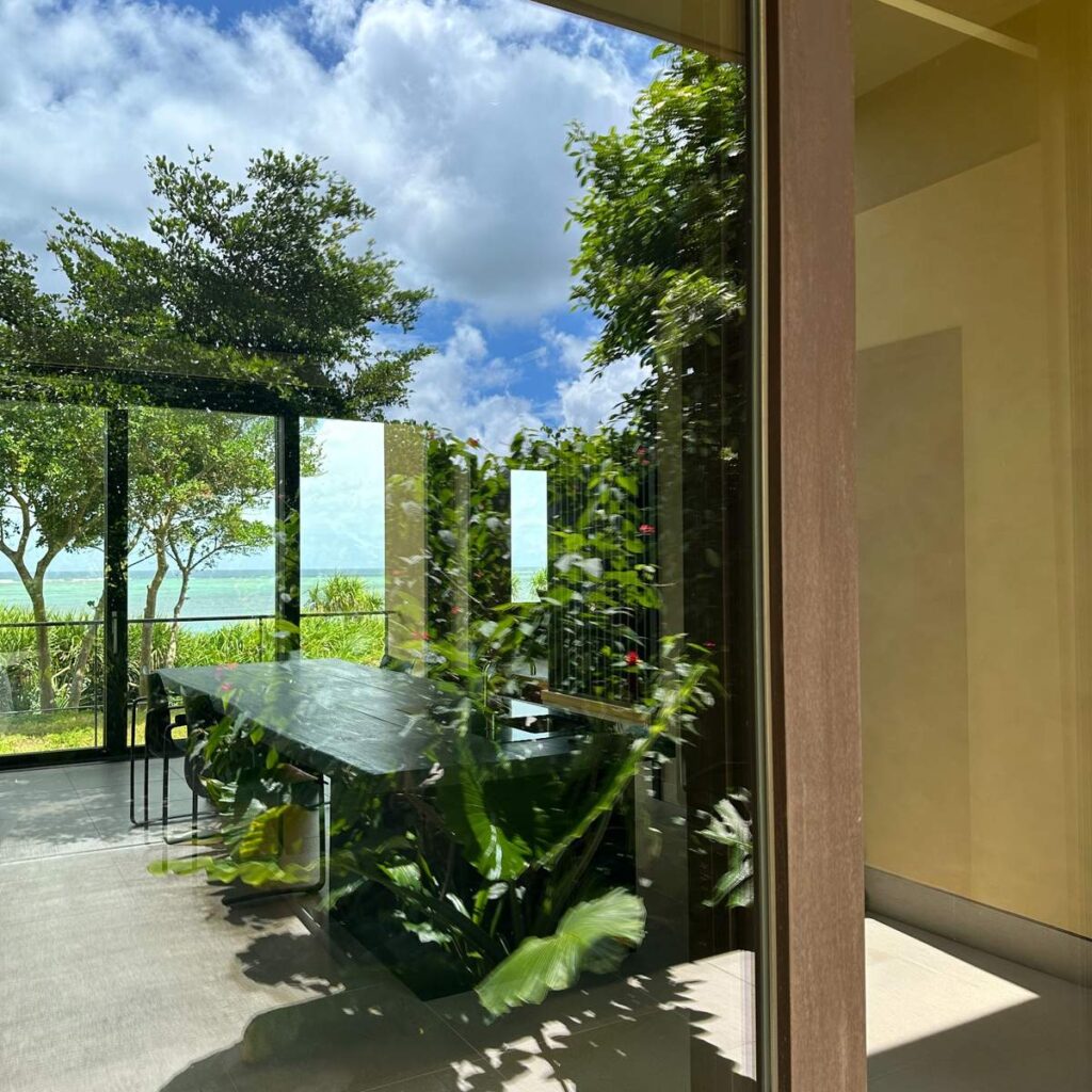 星のや沖縄の客室ガラスに映る沖縄の青い海と空