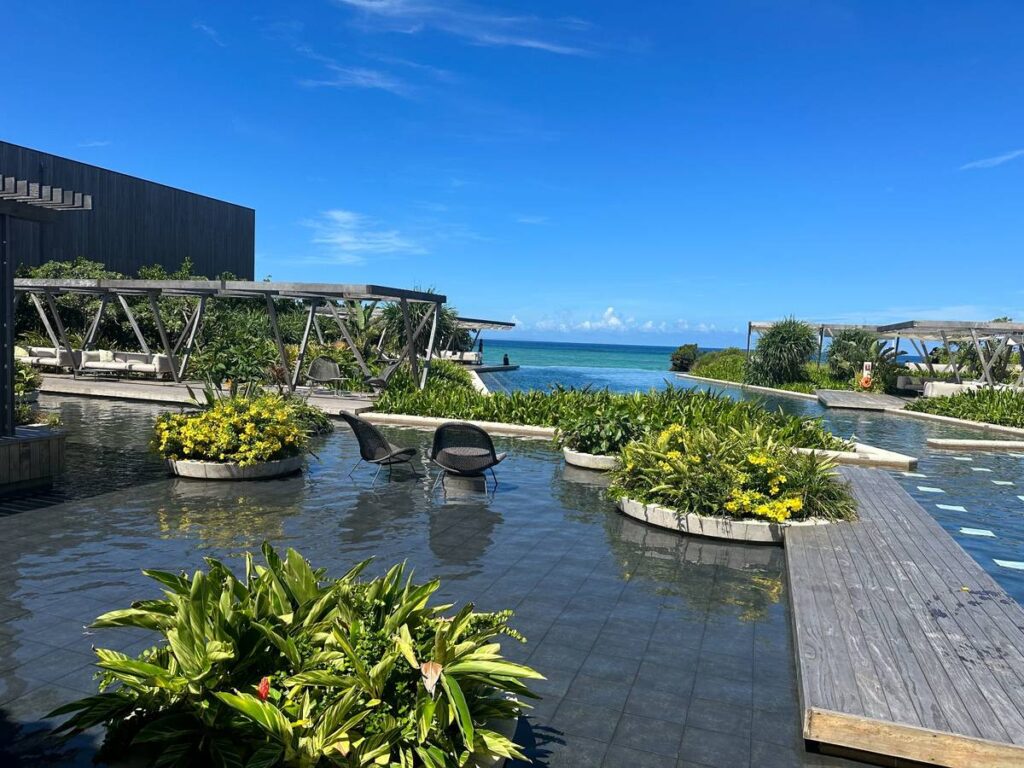 沖縄の青空とエメラルドグリーンの海を望むプール